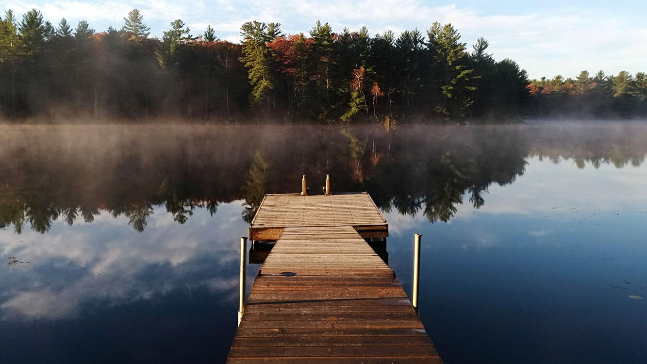 wooden pier on a misty lake in the early morning
