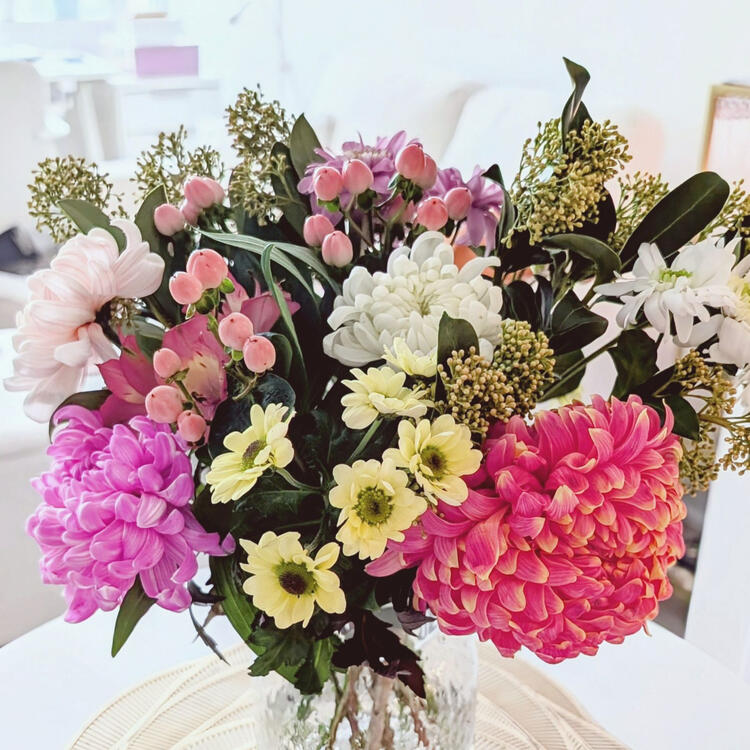 flower arrangement of pink and white chrysanthemums, pink berries, and seeded eucalyptus