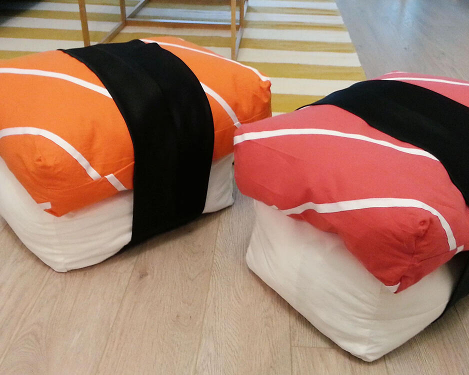 two pillows that mimic salmon and tuna sushi on top of rice, wrapped in seaweed