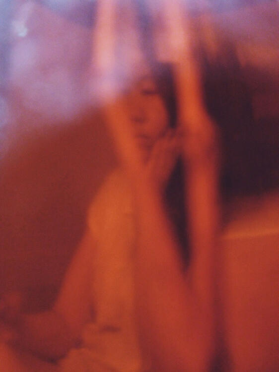 view of a woman through a brown-coloured glass