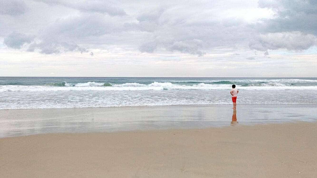 woman standing on the beach by the ocean